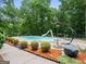 Inviting backyard pool area with lush landscaping and a slide, perfect for summer fun at 124 Belford Way, Locust Grove, GA 30248