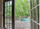 View from the house onto a deck, fence, and pool, surrounded by lush greenery at 124 Belford Way, Locust Grove, GA 30248