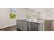 Kitchen island with gray cabinets, stainless dishwasher and granite countertop at 178 Aster, Locust Grove, GA 30248