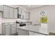 Open concept kitchen with granite counters, gray cabinets, and modern appliances at 178 Aster, Locust Grove, GA 30248