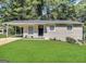Charming single-story home with a well-manicured lawn and a welcoming black front door at 438 Fedora Nw Way, Atlanta, GA 30331