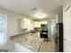 Well-lit kitchen with granite countertops, stainless steel appliances, and white cabinetry at 438 Fedora Nw Way, Atlanta, GA 30331