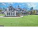 Inviting two-story home features vertical siding, gabled roof, and a lush green lawn at 92 Gordon Oaks Way, Moreland, GA 30259