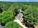 Aerial shot of a house surrounded by lush trees with a paved driveway leading to a two-car garage at 121 Tamerlane, Peachtree City, GA 30269