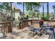 View of the back porch with a round glass table, chairs with blue cushions, and a grill at 121 Tamerlane, Peachtree City, GA 30269