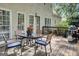 View of the back porch with a round glass table, chairs with blue cushions, and a grill at 121 Tamerlane, Peachtree City, GA 30269