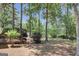 Trees surrounding the back porch and back yard with green grass, soil, and wood chips at 121 Tamerlane, Peachtree City, GA 30269