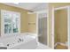 Bright bathroom featuring a soaking tub, tiled floors and glass enclosed shower at 121 Tamerlane, Peachtree City, GA 30269