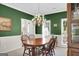 Bright dining room featuring a wooden table with seating, complemented by natural light from surrounding windows at 121 Tamerlane, Peachtree City, GA 30269