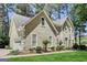 Low angle showing stucco home with front facing garage, complemented by lush green lawn and landscaping at 121 Tamerlane, Peachtree City, GA 30269