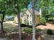 View of a two-story home through the trees featuring beautiful landscaping at 121 Tamerlane, Peachtree City, GA 30269