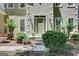Stucco home's welcoming entrance with green door, side-light windows and manicured shrubs at 121 Tamerlane, Peachtree City, GA 30269