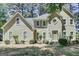 Charming front exterior features light stucco, multi-pane windows, and a meticulously landscaped front yard at 121 Tamerlane, Peachtree City, GA 30269