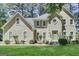 Traditional two-story home with stucco exterior, well-manicured lawn and mature trees at 121 Tamerlane, Peachtree City, GA 30269