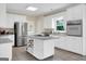 Bright, updated kitchen featuring white cabinets, an island, stainless steel appliances, and wine rack at 121 Tamerlane, Peachtree City, GA 30269