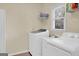 Bright laundry room with a washing machine, dryer, sink, and storage shelves at 121 Tamerlane, Peachtree City, GA 30269