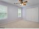 Light-filled bedroom with two windows, carpet floors, ceiling fan, and a closet at 126 Ardenlee Dr, Peachtree City, GA 30269