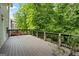 Expansive wooden deck with dark railings, offering an elevated view of the surrounding lush greenery at 126 Ardenlee Dr, Peachtree City, GA 30269