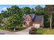 Charming two-story red brick home with a well-manicured front yard and mature trees at 126 Ardenlee Dr, Peachtree City, GA 30269