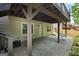 Back patio with a grey paver flooring and a porch swing below a wooden deck, perfect for outdoor lounging at 126 Ardenlee Dr, Peachtree City, GA 30269