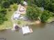 Stunning lakefront property featuring a covered dock, fire pit area, and beautifully landscaped grounds at 22 Waters Bridge Cir, Covington, GA 30014