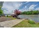 Exterior shot of a lush backyard with a concrete boat ramp and a partially obscured covered dock on the lake at 22 Waters Bridge Cir, Covington, GA 30014