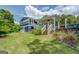 Exterior shot of a backyard with a covered porch and stairs leading up to the beautiful blue house at 22 Waters Bridge Cir, Covington, GA 30014
