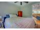 Charming bedroom with hardwood floors, floral quilt, and view into the living room at 22 Waters Bridge Cir, Covington, GA 30014