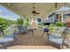 Spacious covered porch with stylish seating, a ceiling fan, and great views of the lush surroundings at 22 Waters Bridge Cir, Covington, GA 30014
