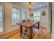 Dining room with a rustic wood table, seating for four, chandelier, and lots of natural light from surrounding windows at 22 Waters Bridge Cir, Covington, GA 30014
