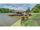Exterior shot of a covered dock with seating and boat slips on the lake in a lush, green environment at 22 Waters Bridge Cir, Covington, GA 30014