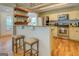 Kitchen area with stainless steel appliances, granite countertops, wooden shelving, and seating for two at the bar at 22 Waters Bridge Cir, Covington, GA 30014