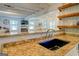 Spacious kitchen features granite countertops and an undermount sink with views into the living and Gathering rooms at 22 Waters Bridge Cir, Covington, GA 30014