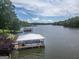 Picturesque view of the lake with a covered dock and lush green trees in the background on a sunny day at 22 Waters Bridge Cir, Covington, GA 30014