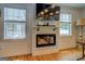 Bright living room features an electric fireplace, TV, and two windows letting in ample natural light at 22 Waters Bridge Cir, Covington, GA 30014
