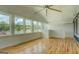 Sunroom with a ceiling fan offering a tranquil lake view through its expansive windows at 22 Waters Bridge Cir, Covington, GA 30014