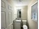 Half bathroom with a granite-topped vanity, toilet, and decorative mirror at 4467 Thornwood Cres, Stone Mountain, GA 30083