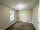 Bedroom with neutral walls, plush carpeting, and a window offering natural light at 4467 Thornwood Cres, Stone Mountain, GA 30083