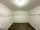 Walk-in closet with carpeted floors and open shelving, offering ample storage space at 4467 Thornwood Cres, Stone Mountain, GA 30083