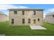 Large backyard with a brick house, concrete patio, and lush green grass at 116 Cabin Way, Hampton, GA 30228