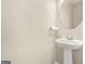 Modern half bathroom featuring a pedestal sink and round mirror at 116 Cabin Way, Hampton, GA 30228