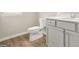Powder room featuring wood-look flooring, a modern toilet, and a vanity with light grey cabinets at 116 Cabin Way, Hampton, GA 30228