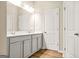 Bathroom featuring a double vanity with grey cabinets and a large mirror, complemented by wood-look flooring at 116 Cabin Way, Hampton, GA 30228
