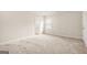 Neutral bedroom featuring plush carpeting, window with blinds, and an ensuite bathroom for added convenience at 116 Cabin Way, Hampton, GA 30228
