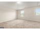 Spacious bedroom featuring neutral walls, plush carpet, and ample natural light from two large windows at 116 Cabin Way, Hampton, GA 30228