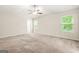 Spacious carpeted bedroom featuring a ceiling fan and natural light from two windows at 116 Cabin Way, Hampton, GA 30228