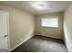 Cozy bedroom has neutral walls, carpeted floors, and a bright window at 815 Magna Carta Nw Dr, Atlanta, GA 30318