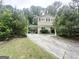 Two-story home boasts an attached carport, surrounded by lush greenery and mature trees at 815 Magna Carta Nw Dr, Atlanta, GA 30318