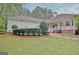 Well-maintained backyard with lush lawn, decorative shrubs, and a covered patio for outdoor enjoyment at 120 Hamilton Glen Ct, Fayetteville, GA 30215