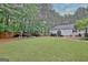 Large backyard with mature trees behind a white vinyl sided house at 120 Hamilton Glen Ct, Fayetteville, GA 30215